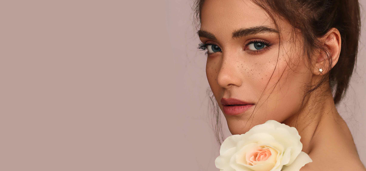Woman with a white rose against a plain background